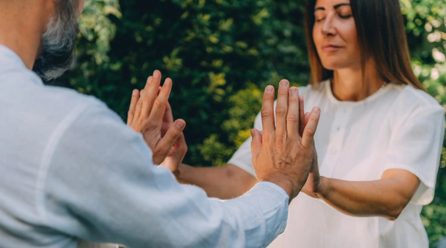 lady aligning hands with man with her eyes closed