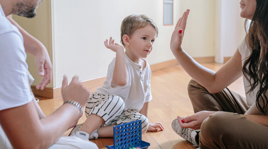 man and lady giving little boy high hive