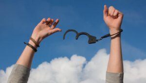 Person breaking free from chains symbolizing escaping a toxic marriage and divorcing a narcissist.