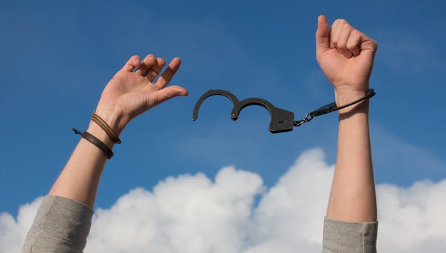 Person breaking free from chains symbolizing escaping a toxic marriage and divorcing a narcissist.