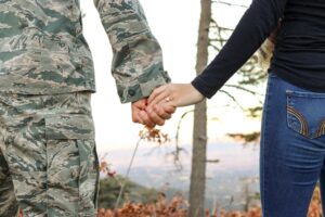 Military divorce in New Jersey illustrated by separated military couple holding hands.